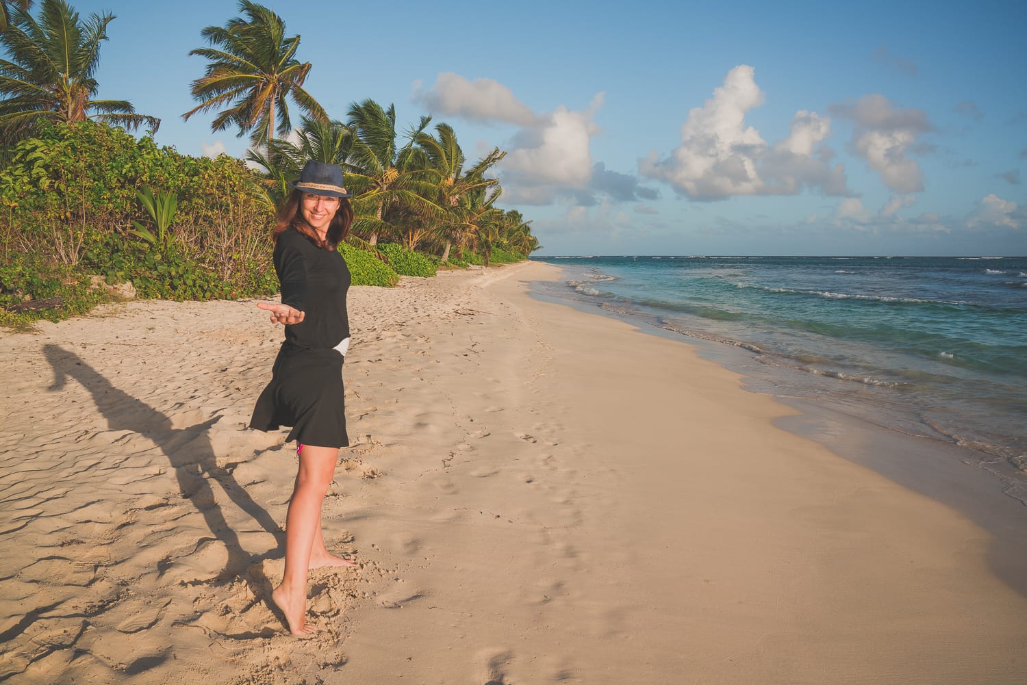 Chica posando a la orilla de la playa en paisaje